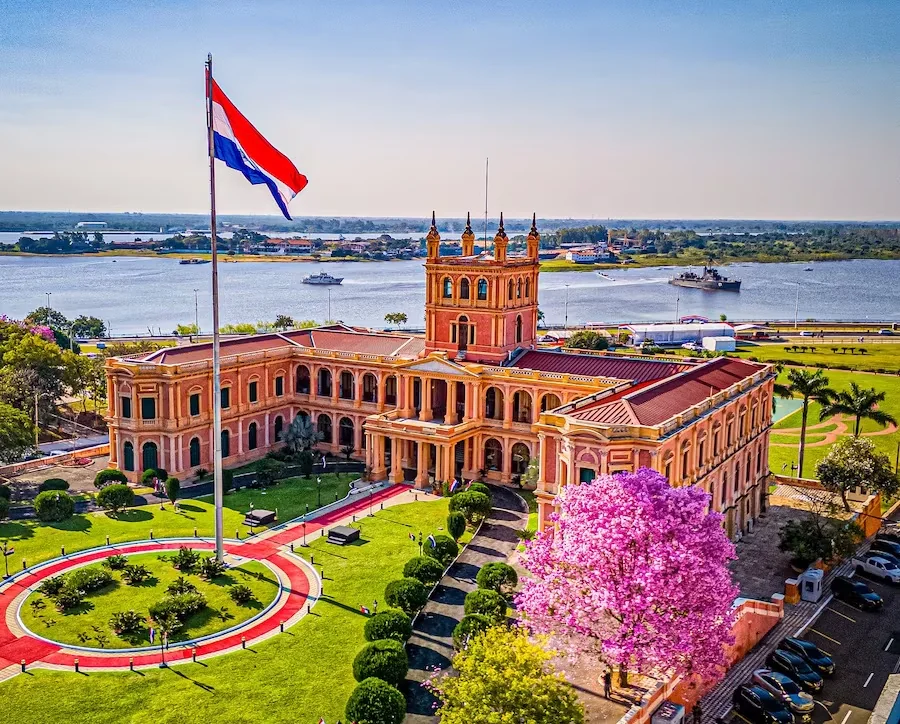 Palacio de López and the Paraguayan flag beside the river in Asunción